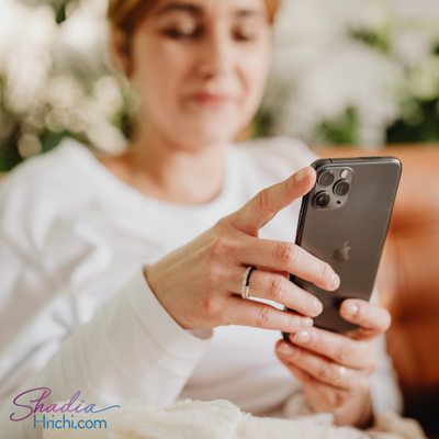 woman sitting on couch scrolling social media on iphone